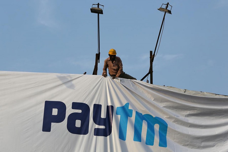 A worker adjusts a hoarding of Paytm, a digital payments firm, in Ahmedabad, India on January 31, 2019 — Reuters/Files