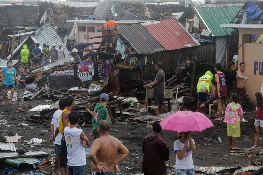 Residents stand among their damaged houses after Typhoon Kammuri hit Legazpi City, Albay, Philippines on Monday — Reuters photo