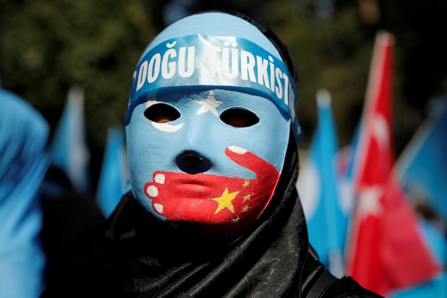 FILE PHOTO: An ethnic Uighur demonstrator wears a mask as she attends a protest against China in front of the Chinese Consulate in Istanbul, Turkey, October 1, 2019. REUTERS/Huseyin Aldemir