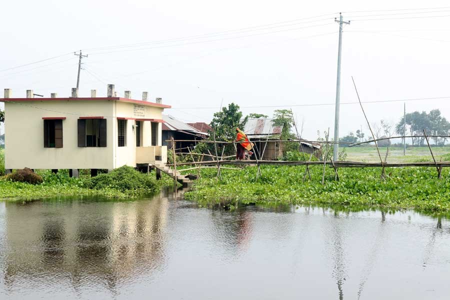 A patient using a bamboo-bridge to go to Hatgram Community Clinic under Bhangura upazila in Pabna district as it is the only way to reach the health centre  	— FE Photo