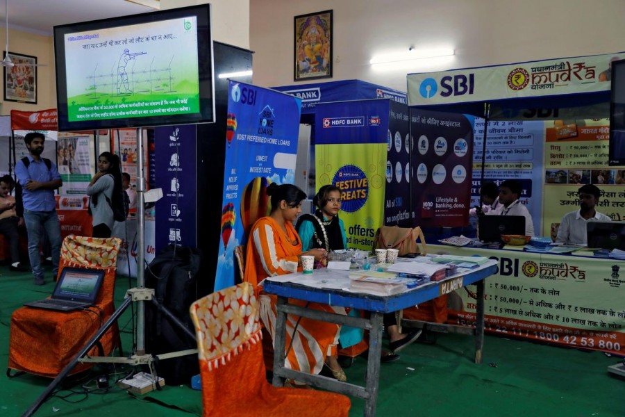 Employees of State Bank of India (SBI) wait for customers to offer loans at a "loan mela" or a loan fair, organised by various Indian banks in New Delhi, India, October 4, 2019. Reuters