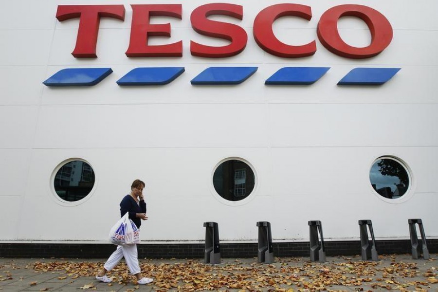 A shopper passes a Tesco supermarket in London October 5, 2011. REUTERS/Luke MacGregor