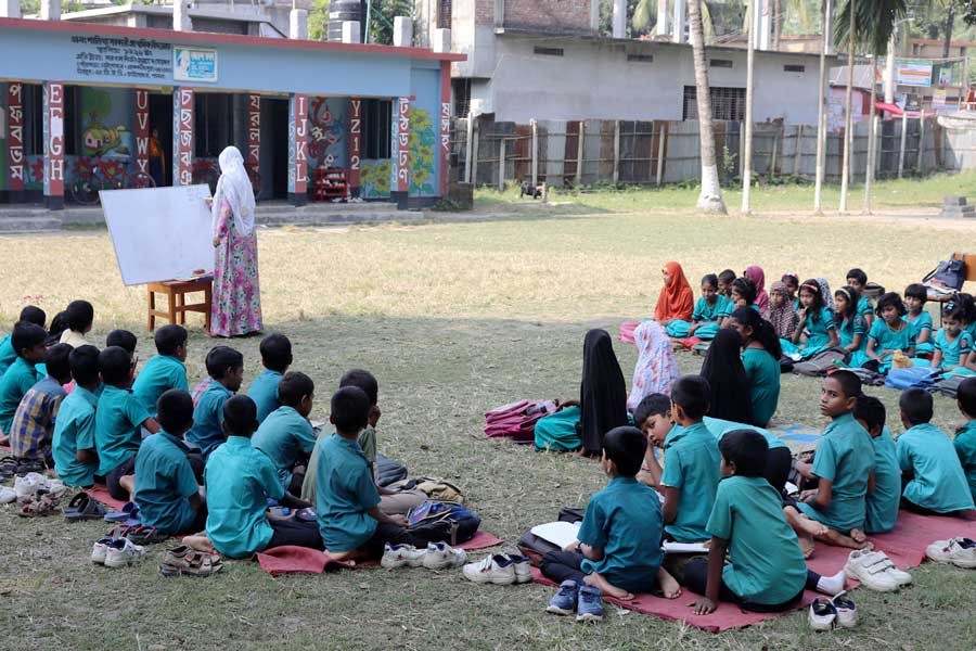 A teacher of Shalikha Government Primary School teaching students under open sky at Chatmohar Upazila Sadar in Pabna district  	— FE photo                                               A teacher of Shalikha Government Primary School teaching students under open sky at Chatmohar Upazila Sadar in Pabna district  	— FE photo
