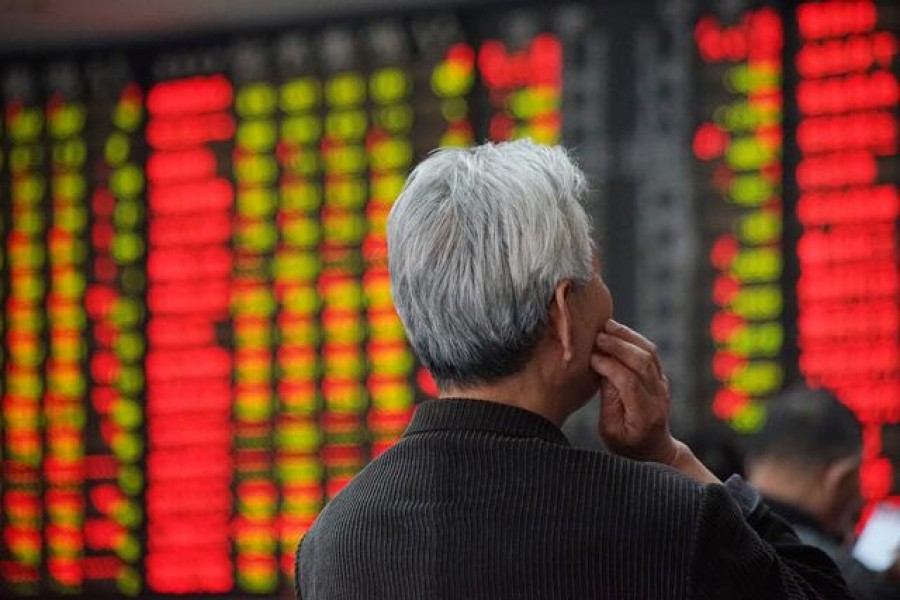An investor looks at an electronic board showing stock information at a brokerage house in Nanjing, Jiangsu province, China, April 16, 2018. Reuters/Files