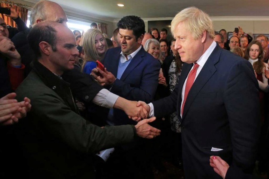 Britain's prime minister Boris Johnson shakes hands with supporters during a visit to see newly elected Conservative party MP for Sedgefield, Paul Howell at Sedgefield Cricket Club in County Durham, north east England on December 14, 2019, following his Conservative party's general election victory. Lindsey Parnaby/Pool via Reuters