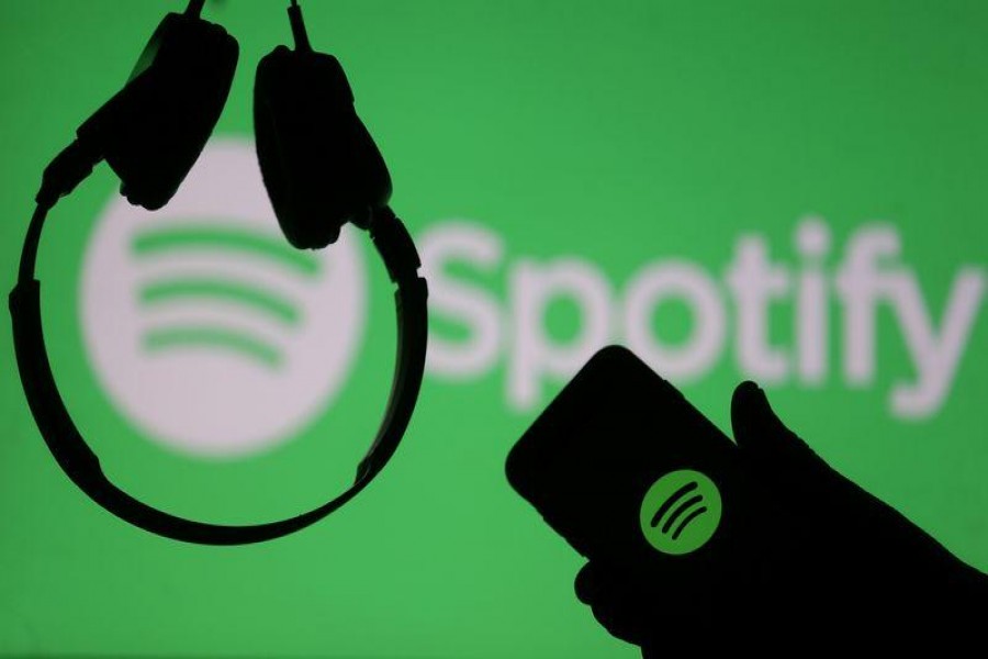 A smartphone and a headset are seen in front of a screen projection of Spotify logo, in this picture illustration taken April 1, 2018. REUTERS/Dado Ruvic/Illustration