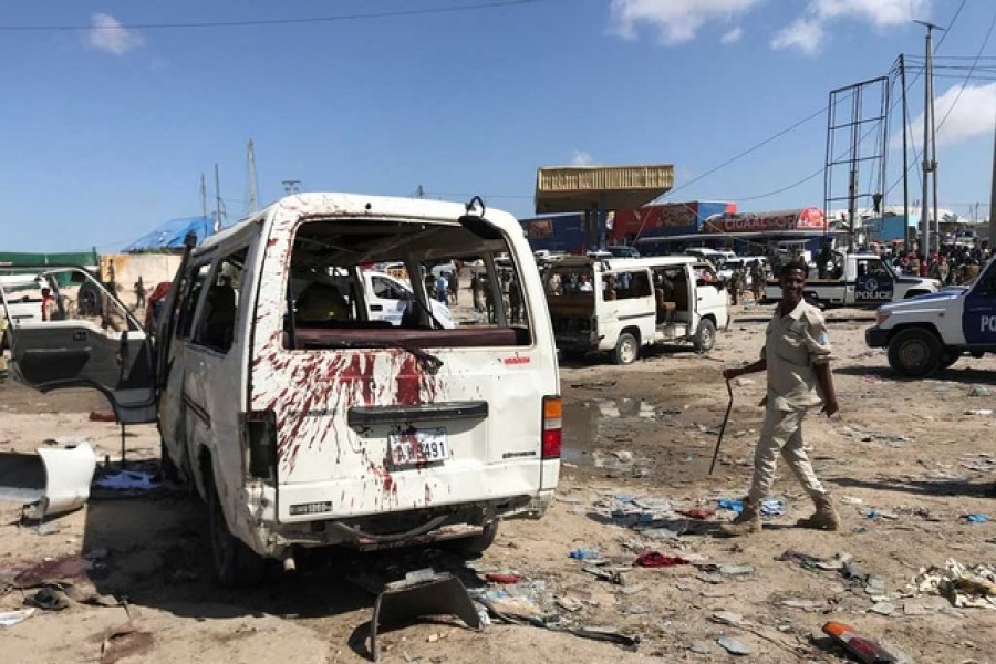 Somali security assess the scene of a car bomb explosion at a checkpoint in Mogadishu, Somalia, December 28, 2019. Reuters
