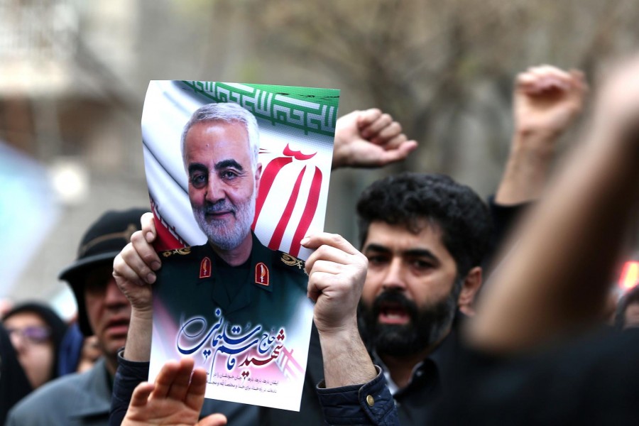 Iranian guards hold a picture of the late Iranian major-general Qassem Soleimani, during a protest against the killing of Soleimani, head of the elite Quds Force, and Iraqi militia commander Abu Mahdi al-Muhandis, who were killed in an air strike at Baghdad airport, in front of United Nation office in Tehran, Iran, January 03, 2020. WANA (West Asia News Agency)/Nazanin Tabatabaee via Reuters