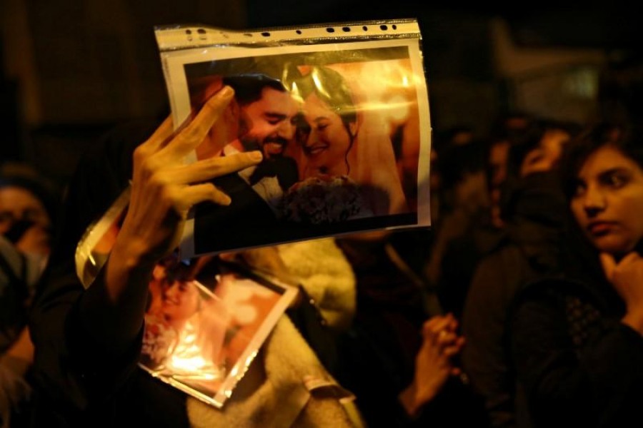 A woman holds a picture of newlyweds, victims of the crash of the Boeing 737-800 plane, flight PS 752, as people gather to show their sympathy in Tehran, Iran, January 11, 2020. Nazanin Tabatabaee/WANA (West Asia News Agency) via Reuters/File Photo