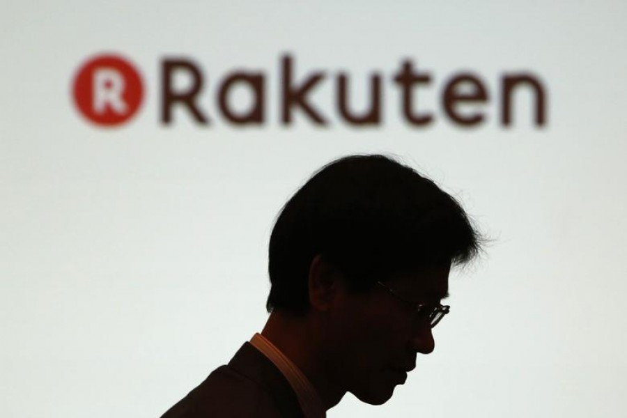 A man walks under a logo of Rakuten Inc during a news conference in Tokyo February 14, 2014. REUTERS/Yuya Shino