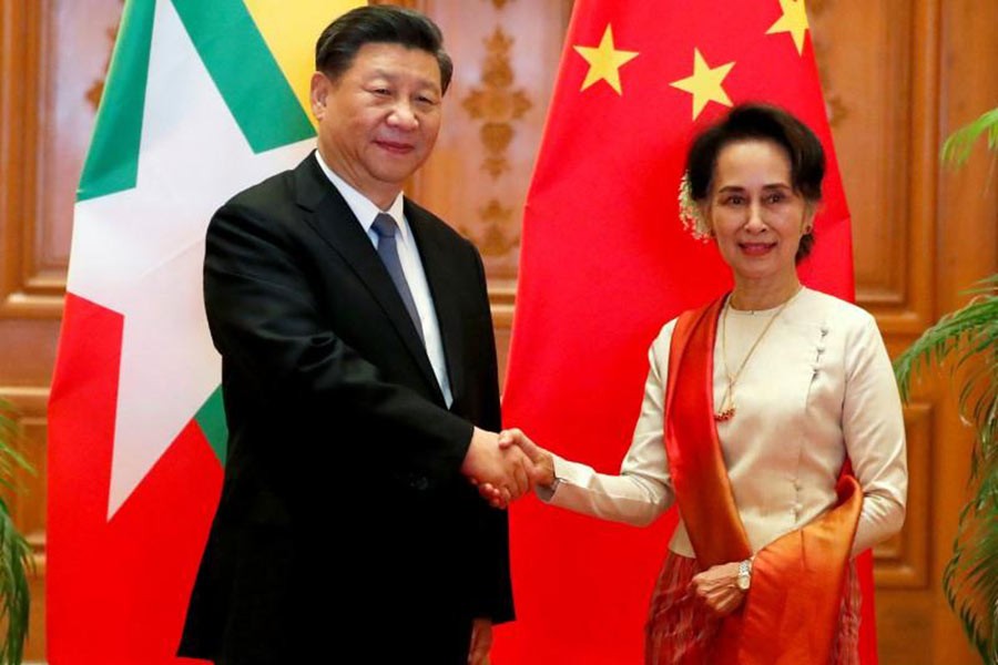 Myanmar State Counselor Aung San Suu Kyi shaking hands with Chinese President Xi Jinping at the Presidential Palace in Naypyitaw, Myanmar, on Saturday. -Reuters Photo