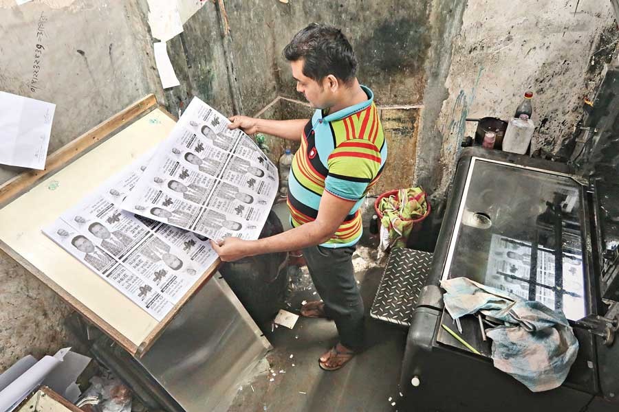 A pressman checking clarity of an election poster being printed at a press in Fakirerpool in the city on Monday ahead of the mayoral elections — FE photo