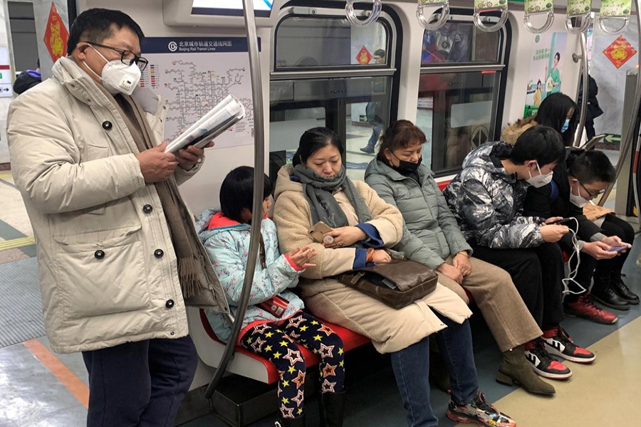 A man wearing a mask reads on the subway in Beijing, China on January 21, 2020 — Reuters photo