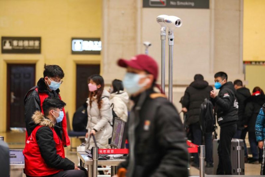 Staff members wearing masks monitor thermal scanners that detect temperatures of passengers at the security check inside the Hankou Railway Station in Wuhan, Hubei province, China on January 21, 2020 — China Daily via REUTERS