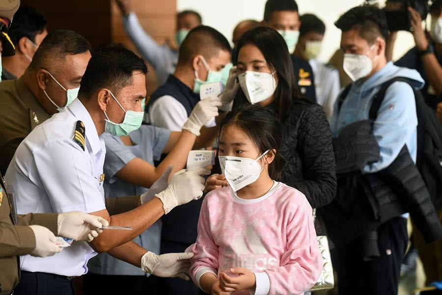 Health workers using infrared thermometers to check the temperature of tourists who arrive at Bangkok's Don Mueang Airport, Thailand, on Saturday. -Reuters Photo
