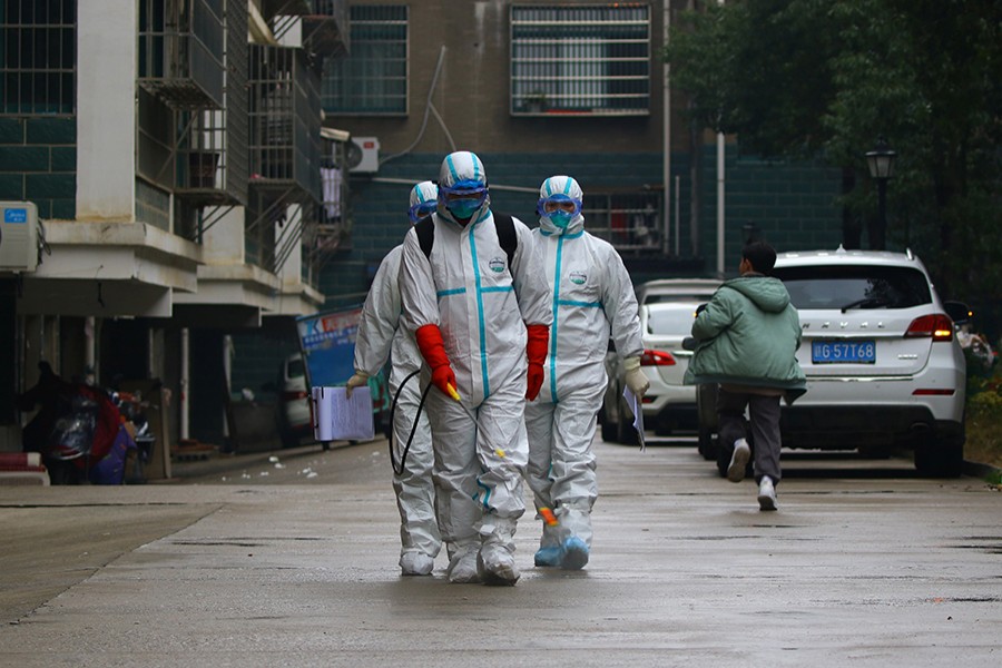 Workers from local disease control and prevention department in protective suits disinfect a residential area following the outbreak of a new coronavirus, in Ruichang, Jiangxi province, China on January 25, 2020 — cnsphoto via Reuters