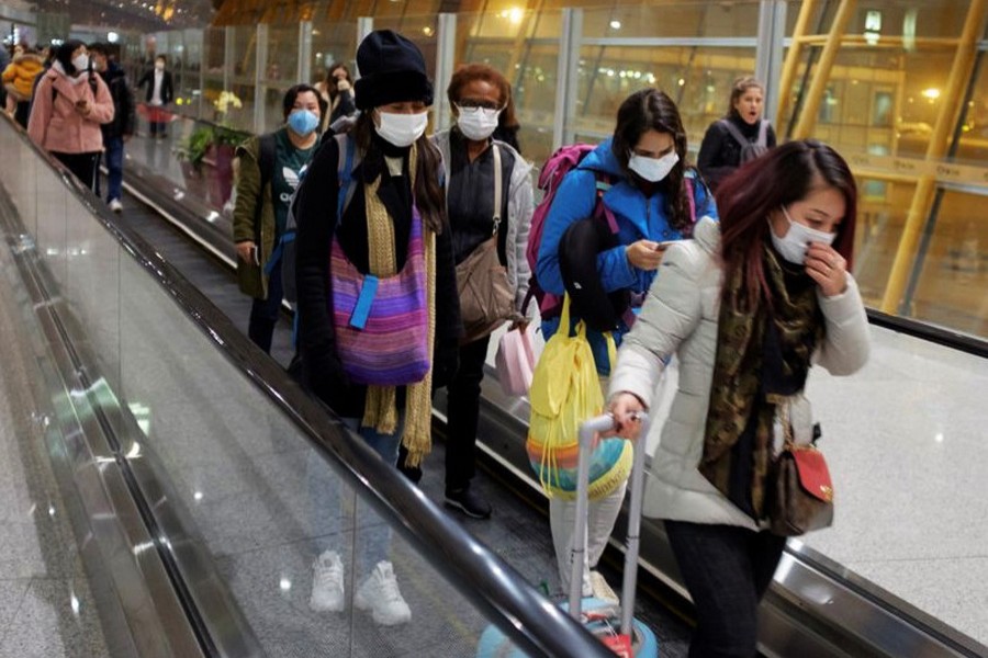 People wear face masks as they arrive at Beijing Capital International Airport in Beijing. (Reuters)