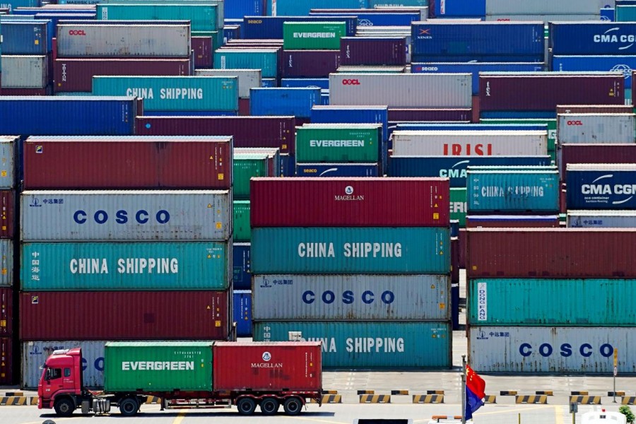 A truck carrying containers is seen near a Chinese flag at the Yangshan Deep Water Port in Shanghai, China, August 6, 2019. Reuters