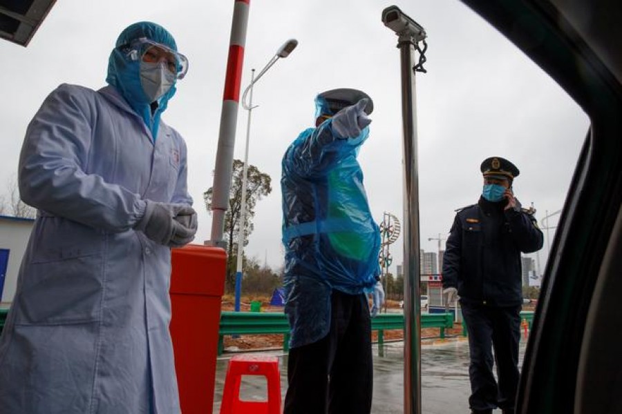 A medical worker and police stand at a checkpoint as the country is hit by an outbreak of the novel coronavirus in Susong County, Anhui province, China, February 06, 2020. Reuters