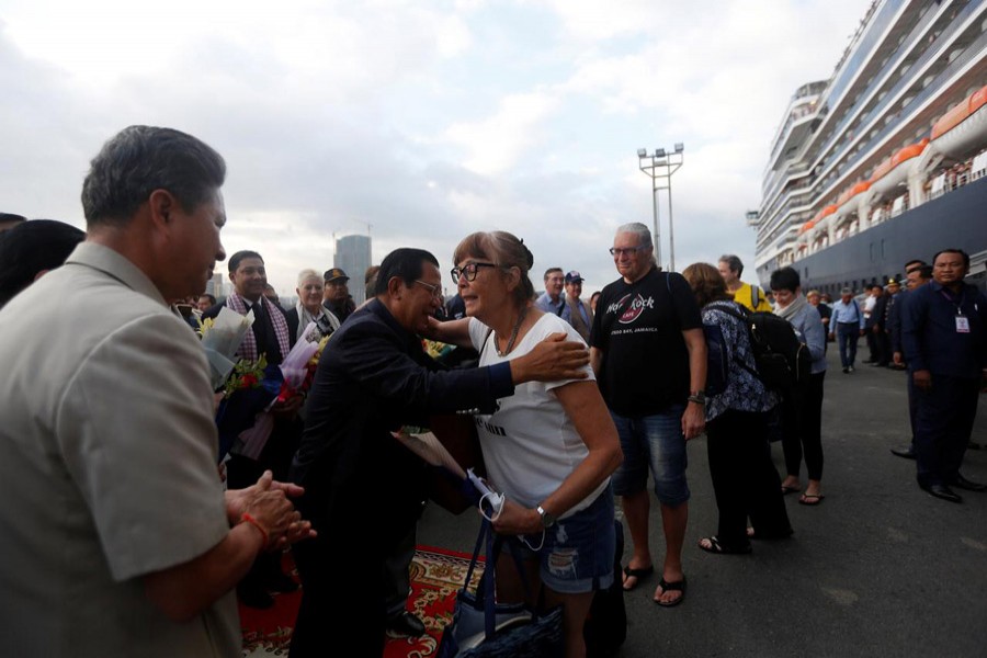 Cambodia's prime minister Hun Sen welcomes passenger of MS Westerdam, a cruise ship that spent two weeks at sea after being turned away by five countries over fears that someone aboard might have the coronavirus, as it docks in Sihanoukville, Cambodia, February 14, 2020. Reuters