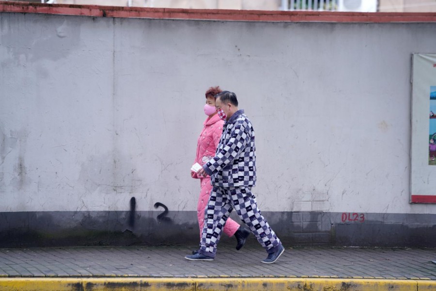Residents wearing face masks and pyjamas are seen on a street in Shanghai, China, as the country is hit by an outbreak of the novel coronavirus, February 14, 2020. Reuters