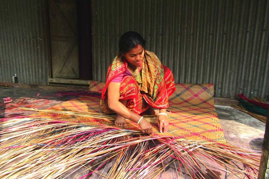 A female artisan weaving mat at her homestead in Mymensingh district    	— FE Photo