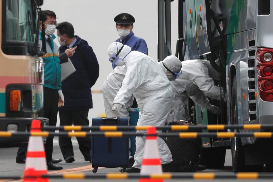 Workers load luggage into a bus as a second group of passengers from the coronavirus-hit Diamond Princess cruise ship disembark in Yokohama Port, south of Tokyo, Japan on February 20, 2020 — Reuters photo