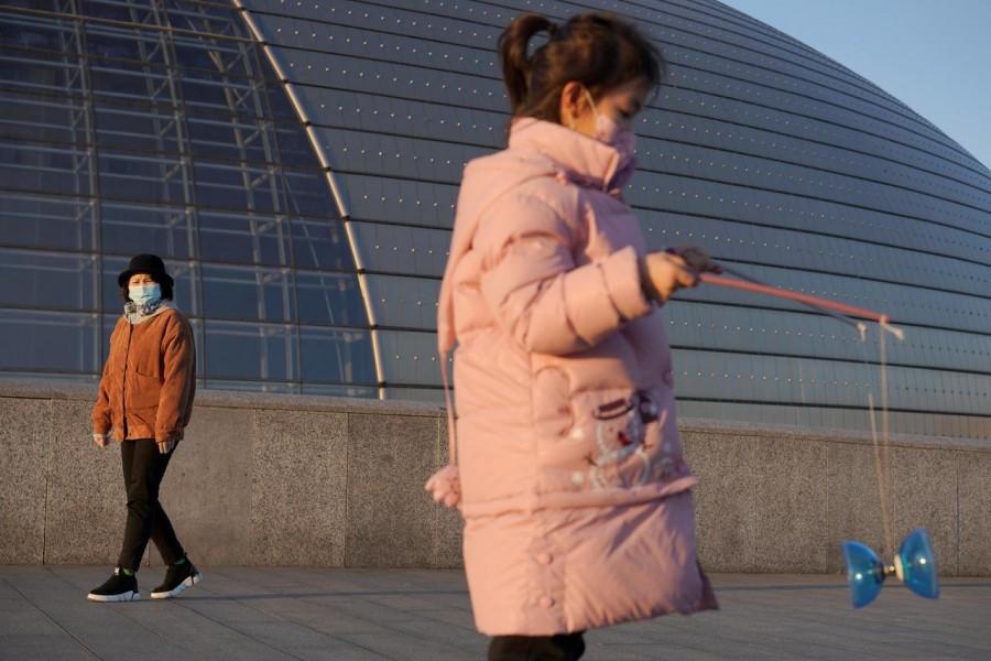 A girl wearing a face mask plays with a diabolo near the National Centre for the Performing Arts, following an outbreak of the novel coronavirus in the country, in Beijing, China, February 22, 2020. Reuters
