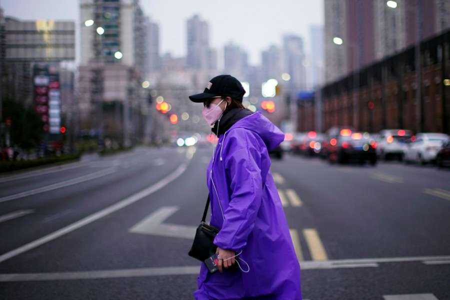A woman wearing a face mask is seen on a street in downtown Shanghai, China, as the country is hit by an outbreak of a new coronavirus, February 26, 2020 — Reuters