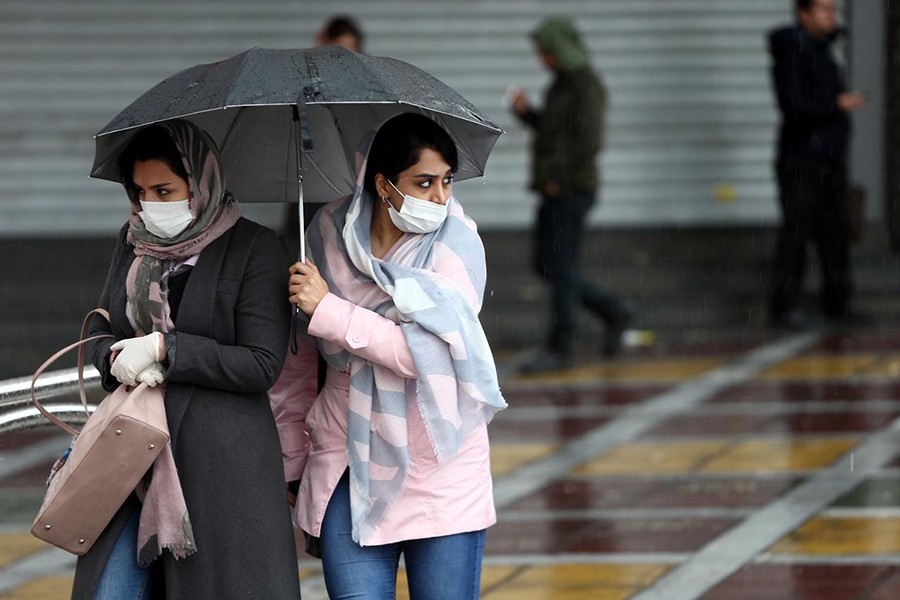 Iranian women wear protective masks to prevent contracting coronavirus, as they walk in the street in Tehran, Iran on February 25, 2020 —  West Asia News Agency via REUTERS