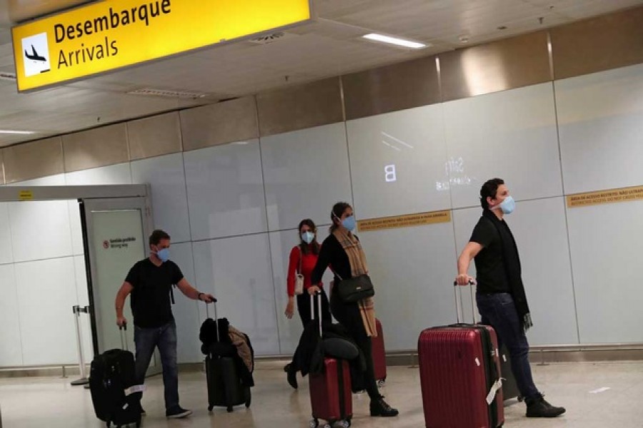 Travellers wearing protective face masks as a precautionary measure arrive on a flight from Italy, after the second case of coronavirus in Sao Paulo was confirmed, at Guarulhos International Airport in Guarulhos, Sao Paulo state, Brazil, February 29, 2020 — Reuters