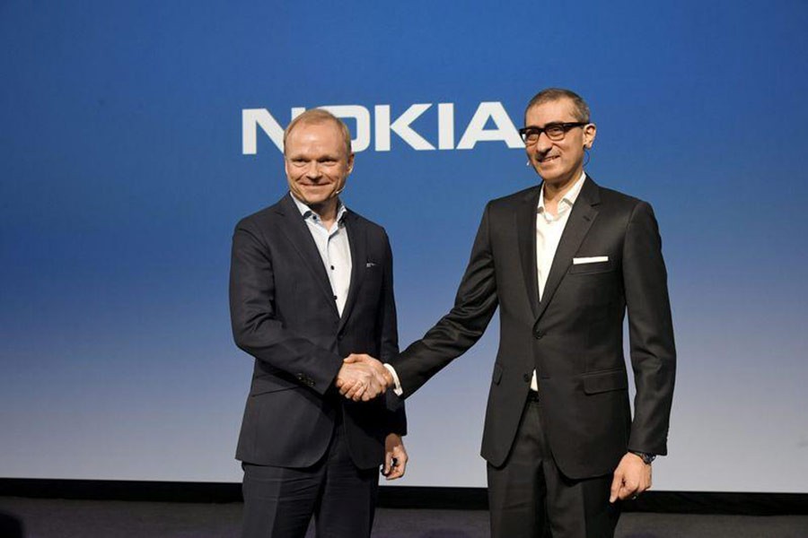 Nokia's new President and CEO Pekka Lundmark shaking hands with resigning President and CEO Rajeev Suri (R) after a news conference at the Nokia headquarters in Finland on Monday. -Reuters Photo