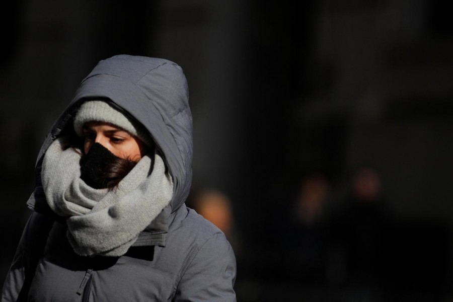 A woman wears a mask on Wall St. near the New York Stock Exchange (NYSE) in New York, U.S., February 28, 2020. REUTERS/Brendan McDermid