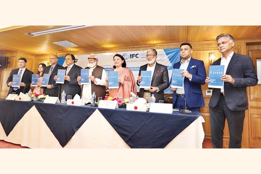 The prime minister's private industry and investment adviser Salman F Rahman (5th from R), MCCI president Nihad Kabir (4th from R), BIDA executive chairman Md Sirazul Islam (3rd from R), former MCCI president Syed Nasim Manzur (extreme right) and representatives from the International Finance Corporation (IFC) posing with the copies of a report titled 'Bangladesh's Journey to Middle Income Status: The Role of the Private Sector' at its launching ceremony at the MCCI office in the city on Wednesday — FE photo