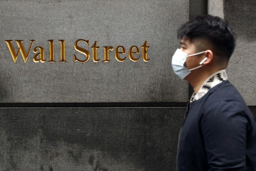 A man wears a protective mask as he walks on Wall Street during the coronavirus outbreak in New York City, New York, US, March 13, 2020. — Reuters