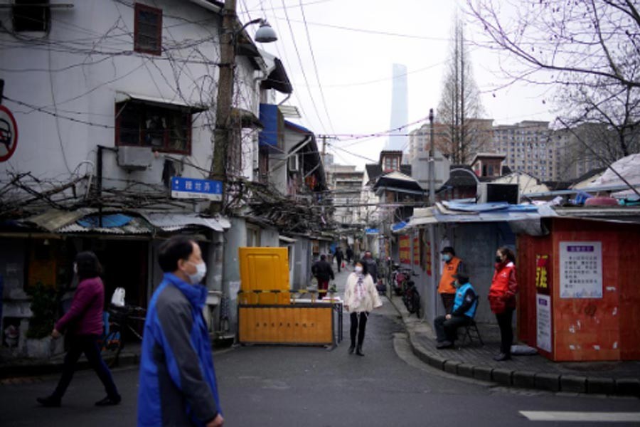 FILE PHOTO: People wear protective face masks at a residential community following an outbreak of coronavirus (COVID-19), in downtown Shanghai, China March 13, 2020. REUTERS/Aly Song