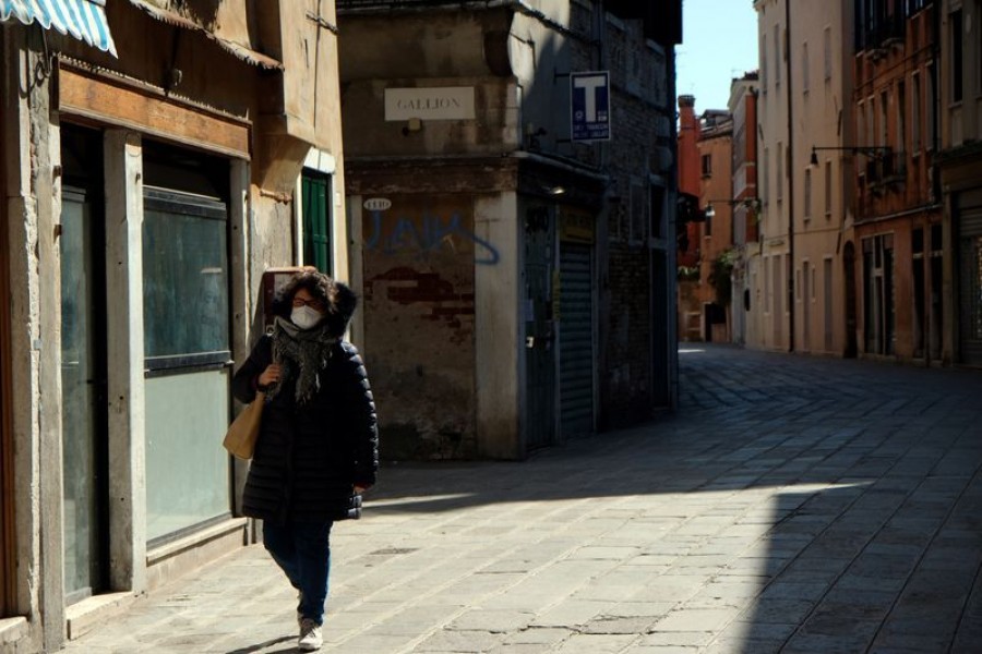 A woman wearing a protective mask in an empty street of Venice on Sunday with an unprecedented lockdown across of all Italy imposed to slow the outbreak of coronavirus, in Venice, Italy on March 15. 2020 — Reuters photo