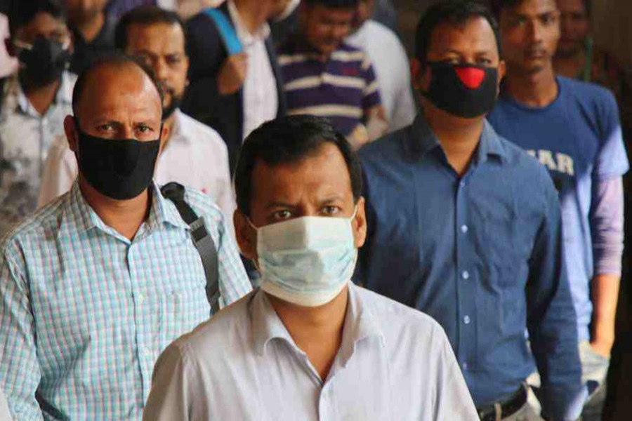 People wear face masks as a precaution after detection of coronavirus patients in the country. — UNB/Files