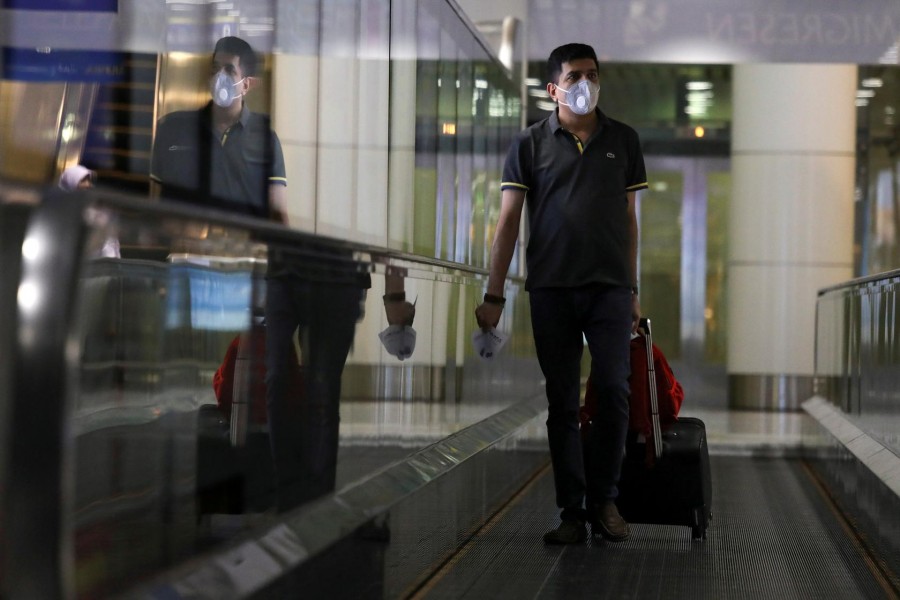 FILE PHOTO: A passenger wearing a protective mask arrives at Kuala Lumpur International Airport, following the coronavirus outbreak, in Sepang, Malaysia March 10, 2020. REUTERS/Lim Huey Teng