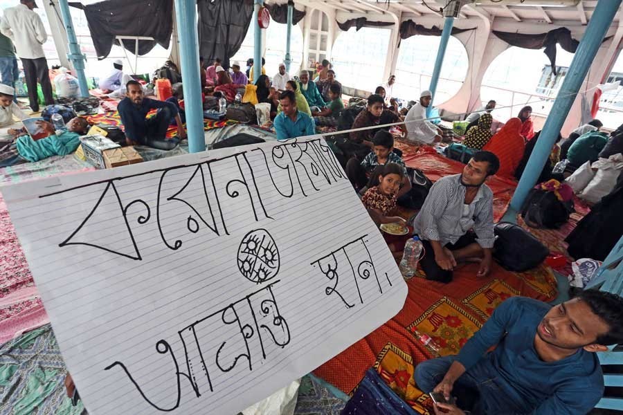 People sitting at a 'place designated for coronavirus-infected persons' aboard a launch at Sadarghat in Dhaka on Friday ignoring the sign — FE photo