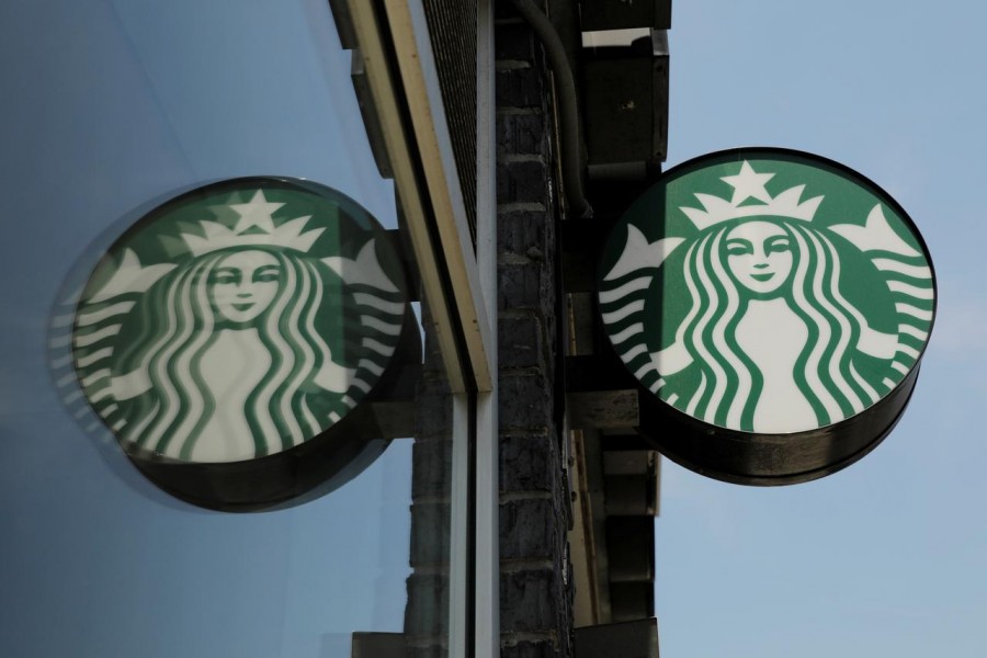 FILE PHOTO: A Starbucks logo hangs outside of one of the 8,000 Starbucks-owned American stores that will close around 2 p.m. local time on Tuesday as a first step in training 175,000 employees on racial tolerance in the Brooklyn borough of New York, US, May 29, 2018. REUTERS/Lucas Jackson