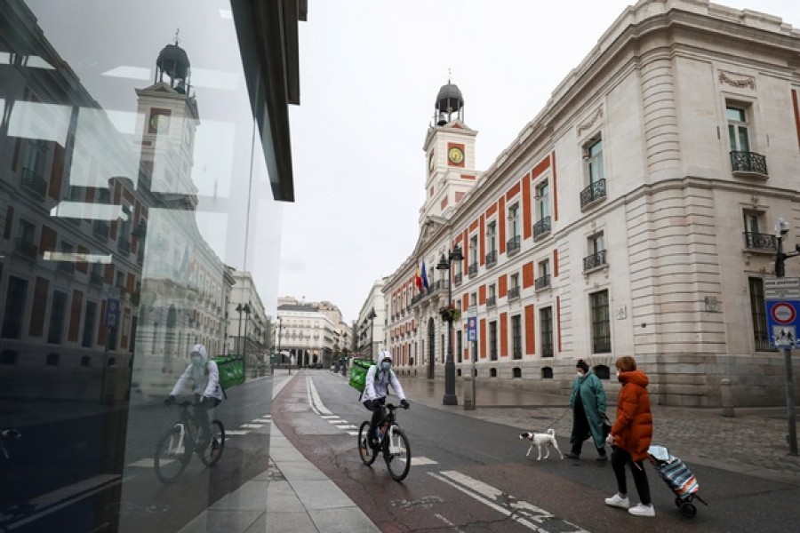 People wearing protective face masks are seen in an almost empty Puerta del Sol during a partial lockdown, which is a part of a 15-day state of emergency to combat the coronavirus disease (COVID-19) outbreak in Madrid, Spain, March 21, 2020. — Reuters