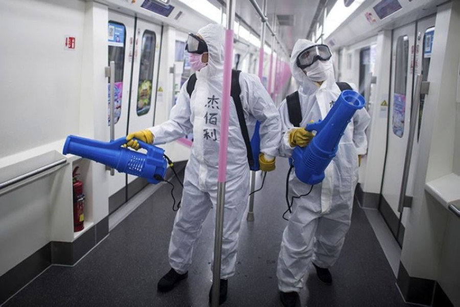 In this March 23, 2020 photo released by Xinhua News Agency, workers disinfect a subway train in preparation for the restoration of public transport in Wuhan, in central China's Hubei province — via AP