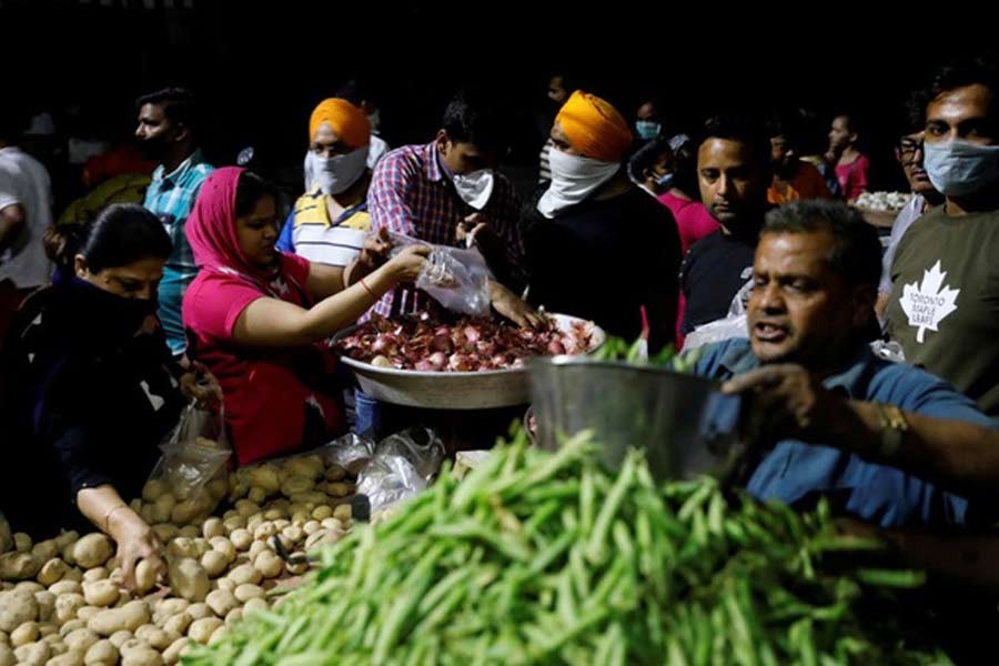 People buying vegetables at a market in New Delhi after Indian Prime Minister Narendra Modi called for a nationwide lockdown starting Tuesday midnight to limit the spreading of coronavirus disease (COVID-19). –Reuters Photo