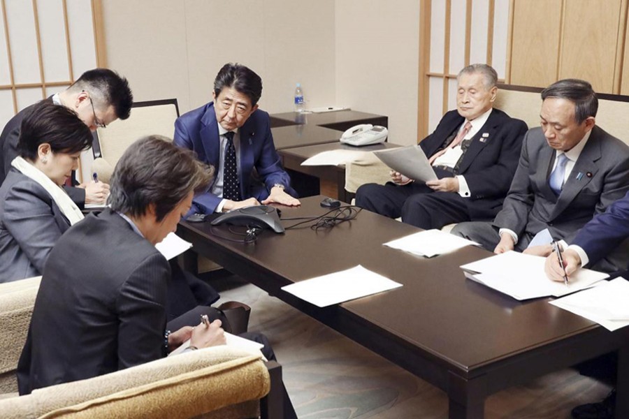 Japan's Prime Minister Shinzo Abe, President of the Tokyo 2020 Organising Committee Yoshiro Mori, Tokyo Governor Yuriko Koike, Olympic Minister Seiko Hashimoto and Chief Cabinet Secretary Yoshihide Suga attend a telephone conference with International Olympic Committee (IOC) President Thomas Bach (not pictured) at Abe's official residence in Tokyo, Japan on March 24, 2020, in this photo released by Japan's Cabinet Public Relations Office via Kyodo — Japan's Cabinet Public Relations Office via Kyodo/via REUTERS