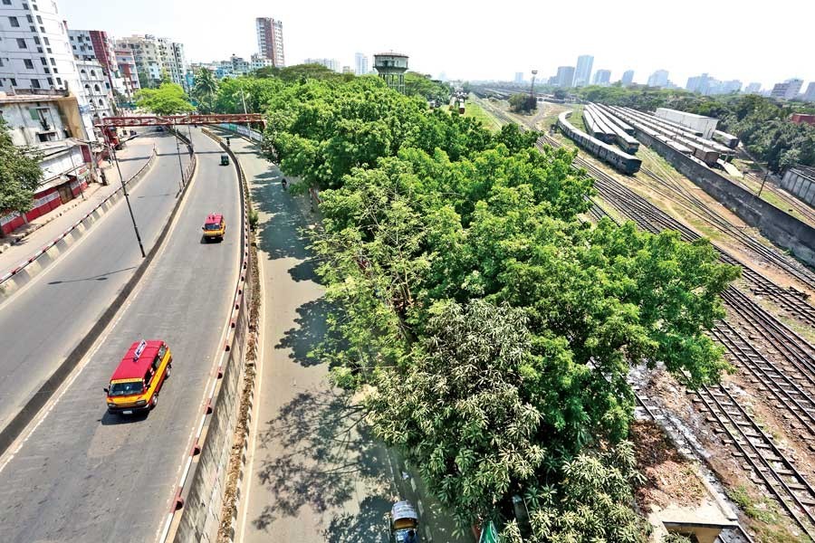 The Khilgaon flyover (left) in the city gives a desolate look while trains (right) stand idle on the railway tracks at the Kamalapur Railway Station on Friday amid the coronavirus scare — FE photo by KAZ Sumon