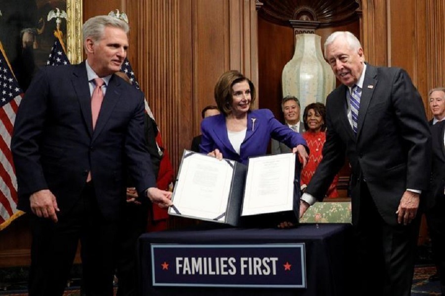 US House speaker Nancy Pelosi (D-CA) is flanked by House minority leader Kevin McCarthy (R-CA) and majority leader Steny Hoyer (D-MD) as she displays the $2.2 trillion coronavirus aid bill during a signing ceremony after the House of Representatives approved the rescue package at the US Capitol in Washington, US, March 27, 2020. — Reuters