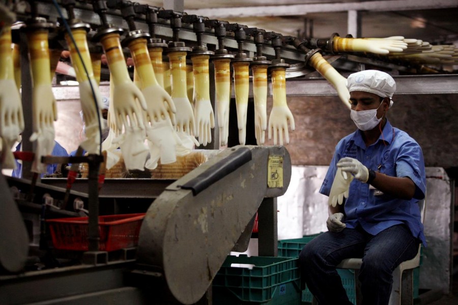 FILE PHOTO: A worker monitors a production line at a Top Glove factory in Meru outside Kuala Lumpur, June 25, 2009. REUTERS/Bazuki Muhammad/File Photo