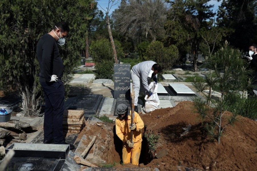 An Iranian man digs a grave to bury the journalist Abdollah Zavieh, who passed away due to coronavirus disease (COVID-19), at Behesht Zahra cemetery in Tehran, Iran, March 24, 2020. WANA (West Asia News Agency)/Ali Khara via REUTERS