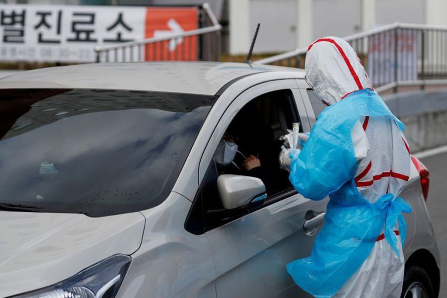 A medical staff preparing to take samples from a visitor at a 'drive-thru' testing center for the novel coronavirus disease of COVID-19 in Yeungnam University Medical Center in Daegu, South Korea last month. –Reuters File Photo